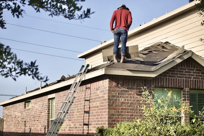 Professional roofer working on a residential roof in Graceland